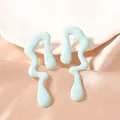 Detailopname van lichtblauwe onregelmatige druppeloorbellen op glanzend satijnen stof - Blauw