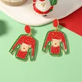 Detail of Christmas sweater earrings with Santa motif and red beads on a festive background - Red Sweater Style / Red