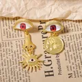 Detailed shot of vintage asymmetric gold earrings featuring evil eye and coin medallion - Red Eye
