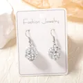 Silver disco ball earrings with mirrored tiles on a white display card for women - Silver