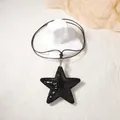 Retro black star pendant necklace with leopard texture on a minimalist display stand - Black Star Pendant