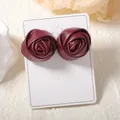 Elegant wine red leather rose stud earrings displayed on a white card in a vintage style - Dark Red