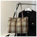 Détail du sac cabas à carreaux avec sangles en cuir et rivets métalliques polis - Vert