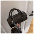 Schwarze Boston-Tasche mit Buchstaben-Prägung und Ledertextur für minimalistischen Stil - Schwarz