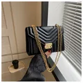 Elegant black quilted chain shoulder bag with gold hardware in a modern lifestyle setting - Black