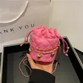 Borsa a secchiello trapuntata rosa con ciondolo a cuore dorato e tracolla a catena - Rosa