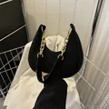Elegante bolso de media luna en ante negro con cadena de oro y cierre de cremallera - Negro