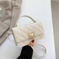 Schicke cremeweiße Stepptasche mit Herzverschluss und goldenem Kettendetail - Gebrochenes Weiß