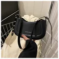 Minimalistische schwarze Hobo-Tasche aus Kunstleder mit Logo und silbernen Metallösen - Schwarz