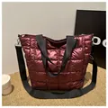 Detail of burgundy quilted tote bag with square stitching and adjustable black strap - Red