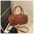 Bruine getextureerde crossbodytas met handvatten en FAS HON reliëfbelettering - Donkerbruin