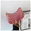 Pink glitter underarm bag with chunky gold chain strap held against a minimalist wall - Rose Red