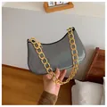Holographic silver underarm bag with bold gold chain strap and curved crescent shape - Black
