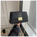 Chic black quilted crossbody bag with gold chain strap and elegant metal clasp - Black