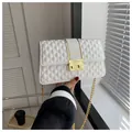 White quilted crossbody bag with gold chain strap and metal clasp detail for women - White