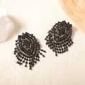 Detailed view of luxury black rhinestone fringe earrings on elegant paper props - Black