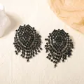 Elegant dark green rhinestone tassel earrings with geometric design in a flat lay view - Dark Green