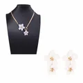 Elegant gold snake chain necklace and double white flower earrings set on black display - Necklace and Earring Set / White