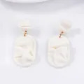 Elegant white matte geometric petal drop earrings with textured pleats and gold rings - White