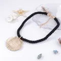 Detail of nautical gold shell pendant with black twisted cord on white background - Black Rope