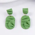 Macro detail of grass green handmade textured leaf-shaped geometric earrings - Green
