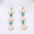 Détail de boucles d'oreilles géométriques en alliage avec pendentifs crème et perles - Blanc