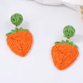 Handgeweven raffia aardbeien oorbellen met oranje textuur en groene bladeren op wit vlak - Aardbeivorm / Aardbei Oranje