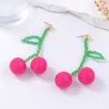 Detail of handmade beaded cherry earrings with pink pearls and green crystal leaf accents - Rose Red