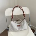 Fashionable tweed crossbody bag with knot shoulder strap on cream chair background - White