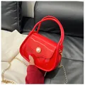 Macro detail of red glossy jelly handbag with gold chain and pearl buckle button - Red