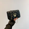 Chic black quilted shoulder bag with golden heart-shaped clasp and delicate chain strap - Black