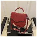 Red crocodile embossed handbag with unique twisted handle and adjustable shoulder strap - Rose Red