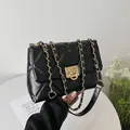 Schicke schwarze Stepptasche mit goldener Kette und elegantem Metall-Drehverschluss - Schwarz