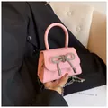 Roze mini handtas van leer met sprankelende strass-strik en zilveren metalen kettingriem - Roze