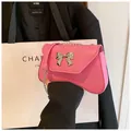Pink leather shoulder bag with silver bow accent and chain strap for women - Pink