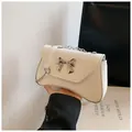 Minimalist white leather crossbody bag with silver bow accent and chain strap - White
