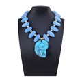 Vue détaillée d'un collier pendentif nautile bleu avec de grandes perles sur un buste - Bleu lac