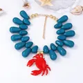 Dettaglio della collana con perle verde acqua e ciondolo granchio con decoro mare - Blu Scuro