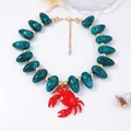 Détail du collier de crabe rouge avec des perles en marbre vert foncé et fermoir doré - Bleu Foncé