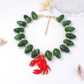 Detail of red enamel crab pendant and marbled olive beads on a nautical style necklace - Dark Green