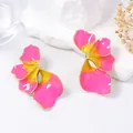 Primer plano detallado de pendientes bohemios con pétalos en degradado rosa y amarillo - Rosa oscuro
