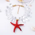 Macro shot of red starfish pendant and transparent teardrop beads on a nautical necklace - Clear