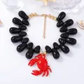 Dettaglio della collana di perle con gocce nere e un ciondolo a forma di granchio - Nero