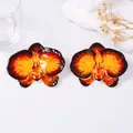 Exaggerated metal orchid earrings with red and yellow enamel glaze on white stone - Orange