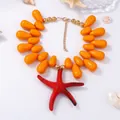 Detail of beaded necklace with orange waterdrop beads and a large red starfish pendant - Orange