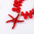 Detail of red starfish pendant with speckled texture and matching glossy teardrop beads - Red