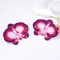 Detailed view of purple enamel orchid earrings with a glossy gradient finish on flower petals - Purple