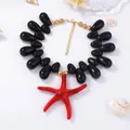 Macro detail of red starfish pendant on black bead necklace with marine style decor - Black