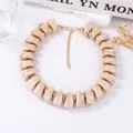 Vue détaillée du collier vintage en perles de résine avec séparateurs dorés et fermoir - Chair