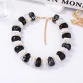Détail de perles en résine marbrée rétro avec entretoises dorées et fermoir mousqueton - Noir & Blanc